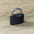 closed iron padlock with a shiny chrome shackle on the wooden surface Royalty Free Stock Photo
