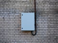 Closed metal electrical panel on a white brick wall Royalty Free Stock Photo