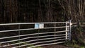 Closed metal gate, on entrance to forestry plantation with warning signs. Royalty Free Stock Photo