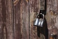 Closed metal lock hanging on the wooden brown old doors