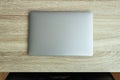 Closed metallic laptop on wooden table. Top view. Office workplace minimal concept Royalty Free Stock Photo