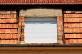 Closed new plastic window blinds covering double window mounted on side of suburban family house below renovated roof