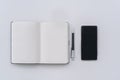 Closed notebook ,pen and mobile phone on white table, flat lay, top view, copy space Royalty Free Stock Photo