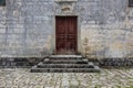 Closed obsolete wooden door and stone bricks steps ancient building