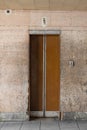 Closed old Soviet wooden elevator doors in the old interior in the style of modernism, with walls lined with travertine Royalty Free Stock Photo