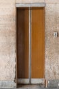Closed old Soviet wooden elevator doors in the old interior in the style of modernism, with walls lined with travertine Royalty Free Stock Photo