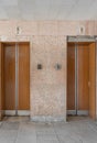 Closed old Soviet wooden elevator doors in the old interior in the style of modernism, with walls lined with travertine Royalty Free Stock Photo