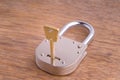Closed Old Style Padlock with key on Wooden Table Royalty Free Stock Photo