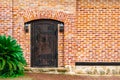 A closed old wooden massive door with cast-iron awnings and a knock on the doorknob in the form of a twisted ring, vintage Royalty Free Stock Photo