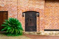 A closed old wooden massive door with a knock on a doorknob in the form of a twisted ring, vintage lanterns hang on both sides of Royalty Free Stock Photo