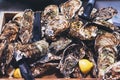 Closed oysters with lemon, fresh oyster shell, mollusks in seafood market, aphrodisiac sea restaurant, expensive fresh food, dish