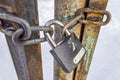 Closed padlock and chains on old and rusty iron gates Royalty Free Stock Photo