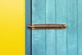 The Closed padlock hangs on the yellow and blue wall doors Royalty Free Stock Photo