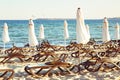 Closed parasols and deckchairs on the sandy beach. Royalty Free Stock Photo