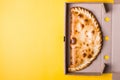Closed pizza calzone in packing box on yellow background Royalty Free Stock Photo