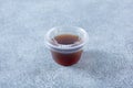 closed plastic condiment cup of red vinaigrette