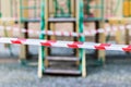 Closed playground during quarantine 2020. White and red warning tape pulled around. Covid-19 Coronavirus Pandemic.Selective focus Royalty Free Stock Photo