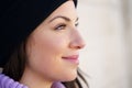 Closed portrait of young woman leaning against a wall outdoors with eyes of hope and joy. Royalty Free Stock Photo