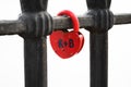 Closed red padlock in the form of heart locked on bridge. Royalty Free Stock Photo