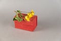 Closed red rectangular box and yellow roses on gray background. Close-up. Selective focus Royalty Free Stock Photo