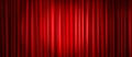 Closed red theater stage curtain with spotlight.