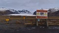 Closed road to SvinafellsjÃÂ¶kull with rockslide warning sign in winter with glacier SkaftafellsjÃÂ¶kull and snow-covered mountains. Royalty Free Stock Photo