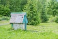 Closed rustic wooden draw-well on forest background