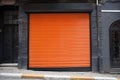 Closed shop exterior covered with orange metal door