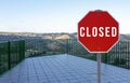 Closed sign with empty lookout point above mountain panorama due to coronavirus outbreak