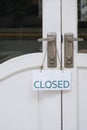 Closed sign label hanging on door handle of the old white vintage door in vertical frame Royalty Free Stock Photo