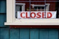 Closed sign in window of green painted wooden building Royalty Free Stock Photo