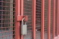 Closed silver lock hanging on red lattice guards industrial