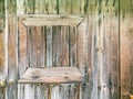 Closed small window frame on weathered wooden barn wall. closeup view Royalty Free Stock Photo