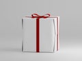 Closed square shaped present box with red ribbon on a plain white background
