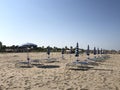 Closed sun umbrellas and empty sun beds on a sandy beach Durres,Albania.