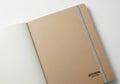 A closed tan colored notebook with a subtle logo is isolated on white background Royalty Free Stock Photo