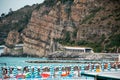 The closed umbrellas on the coast. Ligurian sea. Italy. Mountains in the distance.