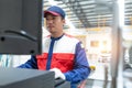 Closed up Asian man mechanic in uniform of an auto wheel : computer wheel alignment. Balancing tire wheel machine. Tyre assembling Royalty Free Stock Photo