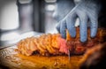 Closed up of chefÃ¢â¬â¢s hand slicing grilled medium rare beef steak on wooden board Barbecue Royalty Free Stock Photo