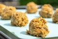 Closed up of cookie dough on baking sheet, brown hazelnuts, raisin and oatmeal put in scoop before put in the oven