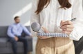 Closed up cropped shot of woman with microphone writing on notebook Royalty Free Stock Photo