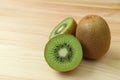 Cross-sections of fresh ripe kiwi fruit with a whole fruit on wooden table Royalty Free Stock Photo