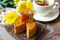 Closed up delicious homemade moon cake on wooden plate with flower tea and dry organic lotus seed on grunge background Royalty Free Stock Photo