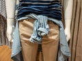 Closed up denim shirt tied around waist on mannequin.