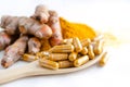 Closed up dry organic turmeric powder in capsule on wooden spoon Royalty Free Stock Photo