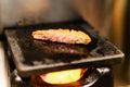 Closed up of fried pork meat grill on hot stone on small fireplace, very delicious traditional japanese food