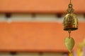 Closed Up Gorgeous Decorated Brass Wind Chime of Buddhist Temple with Blurred Roofs of the Cloister, Nan Province, Thailand