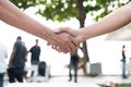 Closed up of hand shake with people in background. Business Cooperation and Unity concept. Business and Outdoors theme Royalty Free Stock Photo