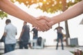 Closed up of hand shake with people in background. Business Cooperation and Unity concept. Business and Outdoors theme Royalty Free Stock Photo