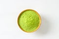 Closed up isolate heap of extract Green Tea powder in wooden bo